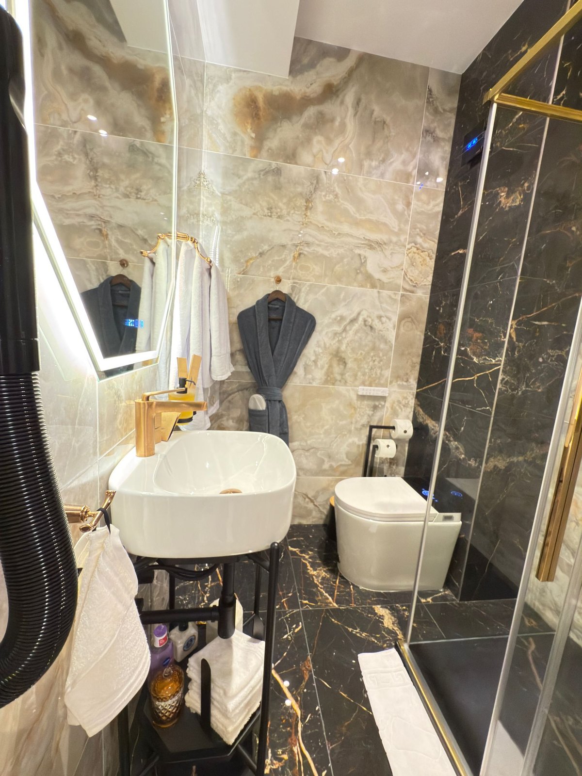 Lavoar din ceramică albă și finisaje aurii în baia Studio Andreea